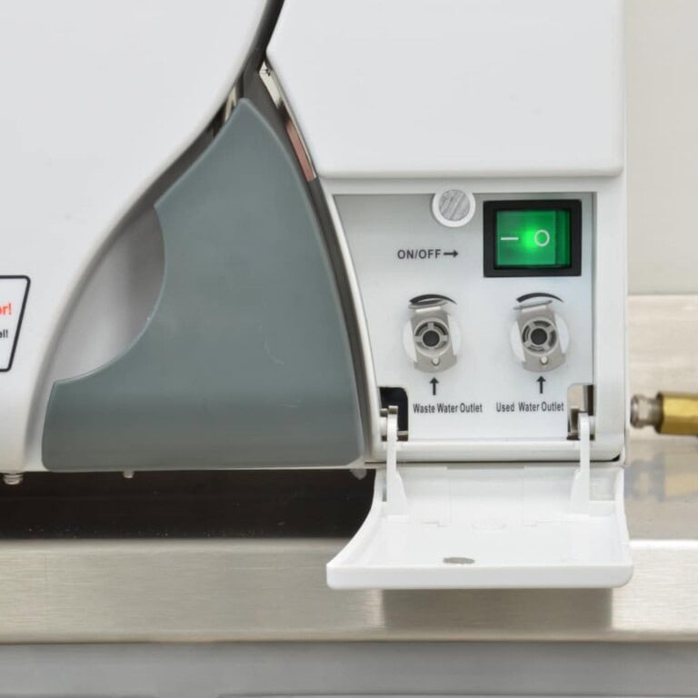 Bajo: Equipo de suministros dentales en clínica dental, con controles y salidas de agua para limpieza y tratamiento dental.
