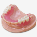 Pieza dental removible con encía rosa, ideal para tratamientos protésicos y restaurativos en odontología, mostrando detalles precisos de la estructura dental y encía artificial.