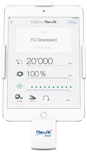 Dispositivo dental iOptima Bien Air con pantalla digital mostrando parámetros de velocidad y presión, usado en tratamientos odontológicos para ajuste y control precisos.